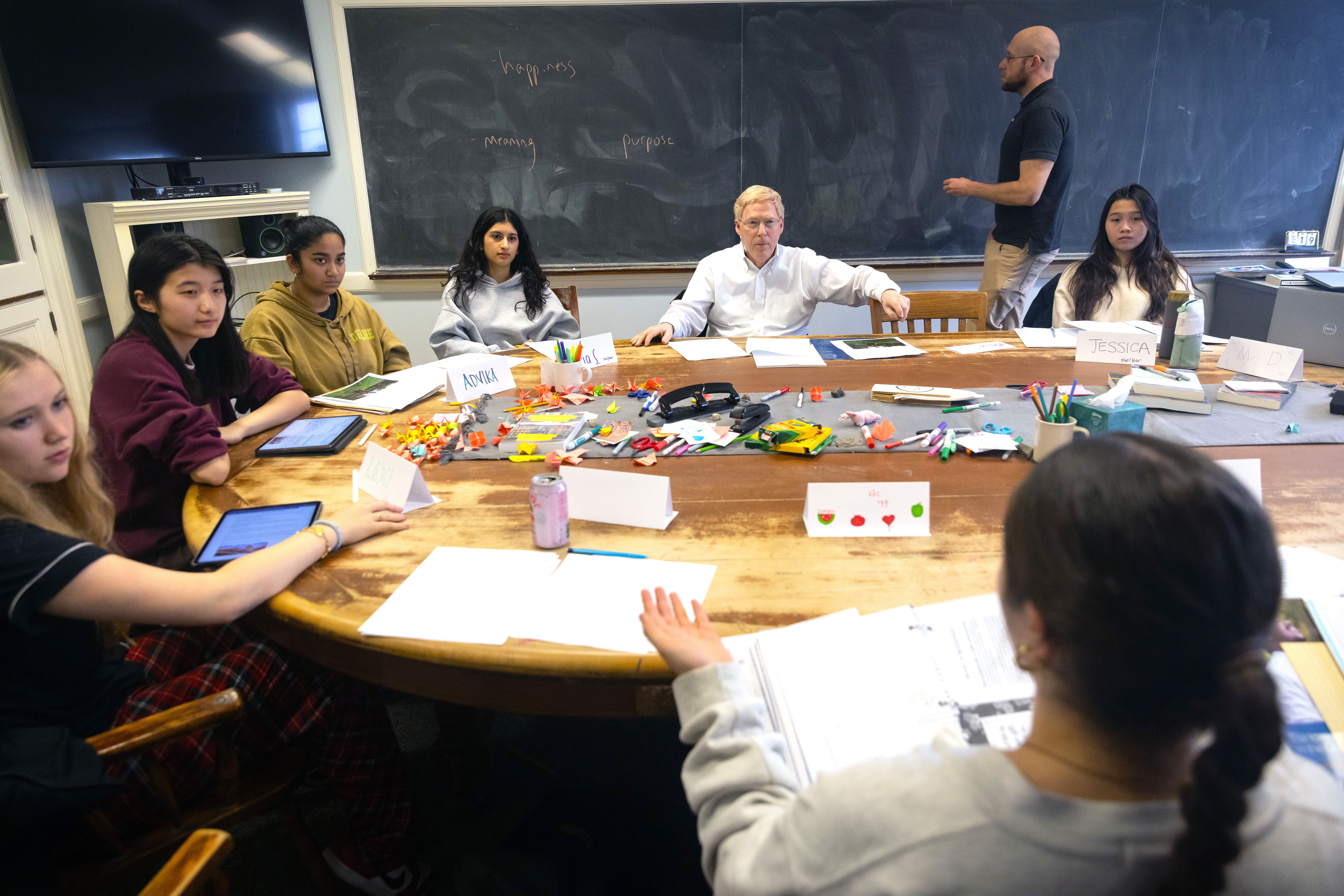 Exonians and Principal Rawson sit around a table