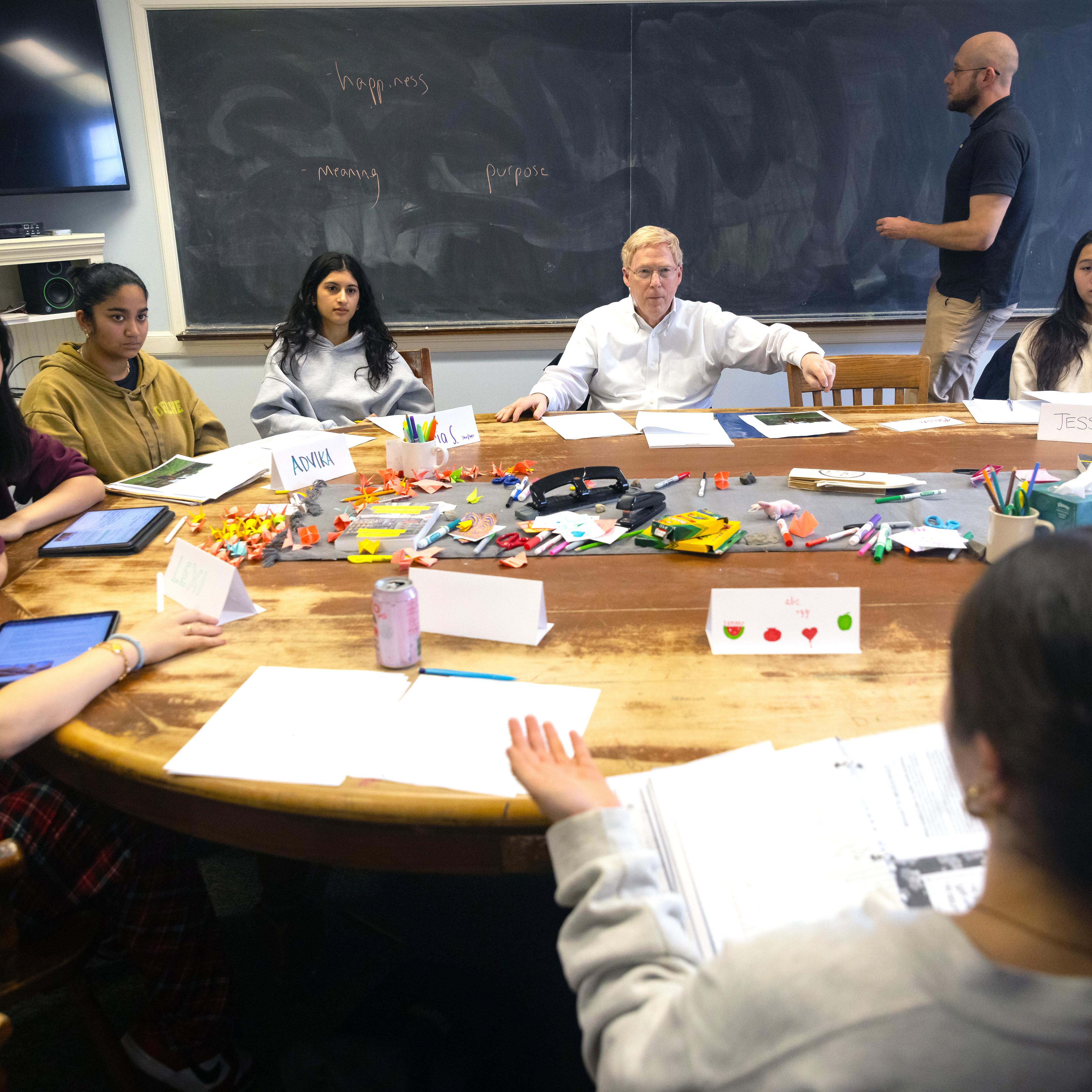 Exonians and Principal Rawson sit around a table