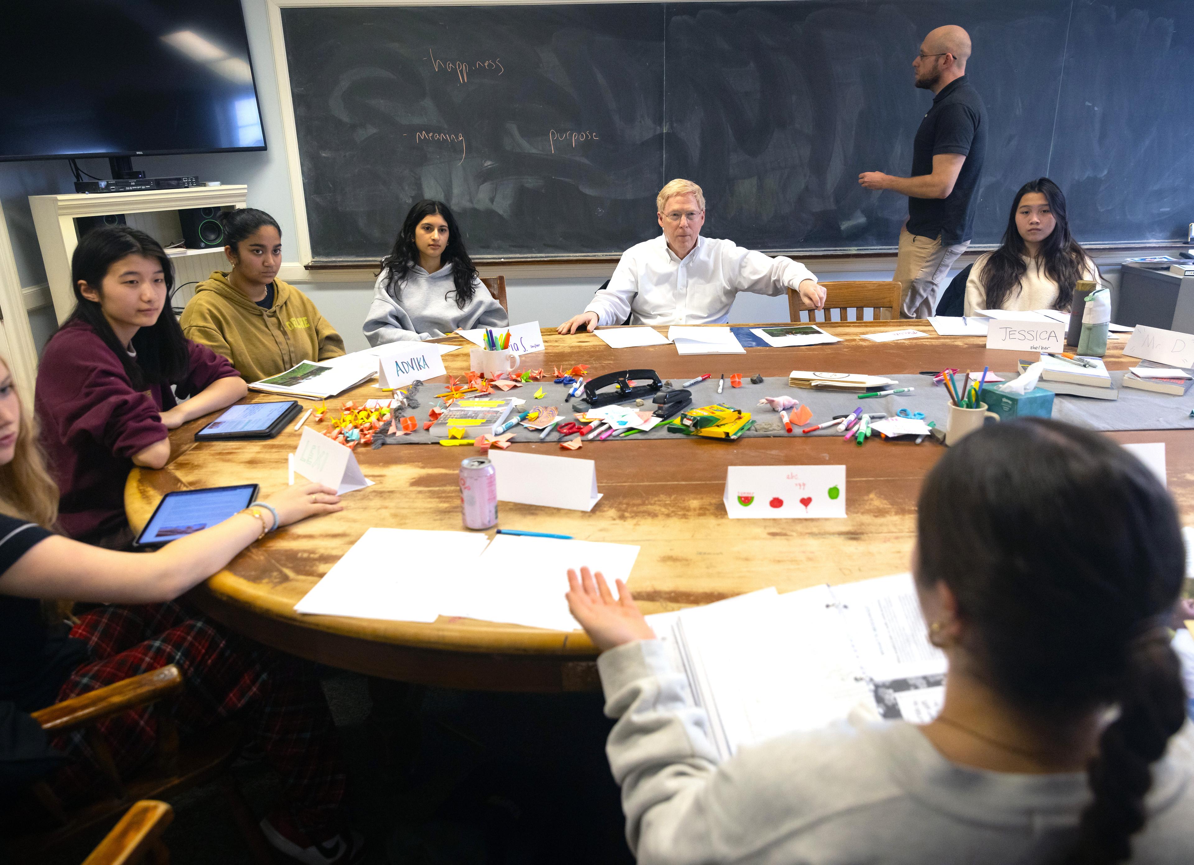 Exonians and Principal Rawson sit around a table