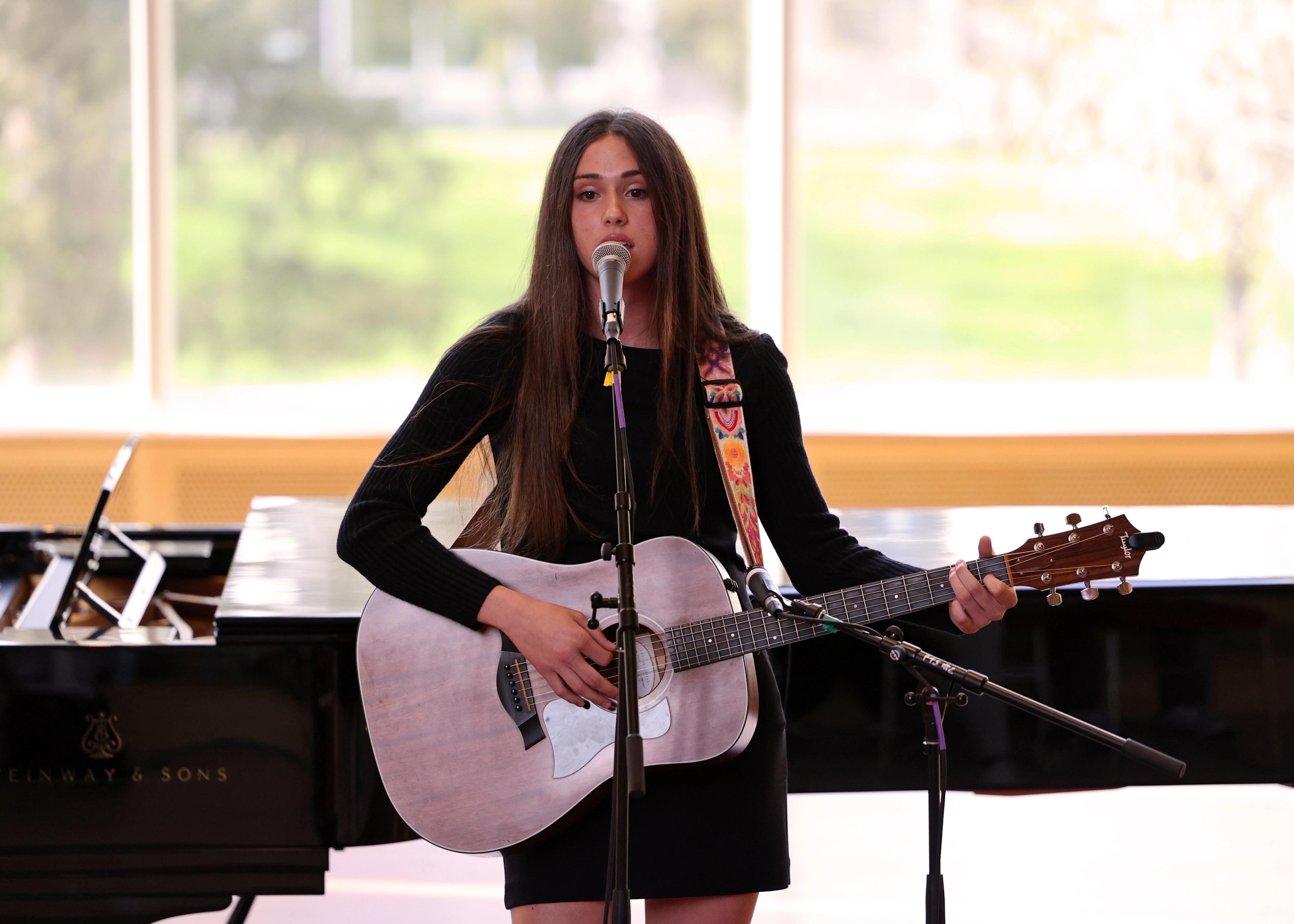 Girl sings and plays guitar