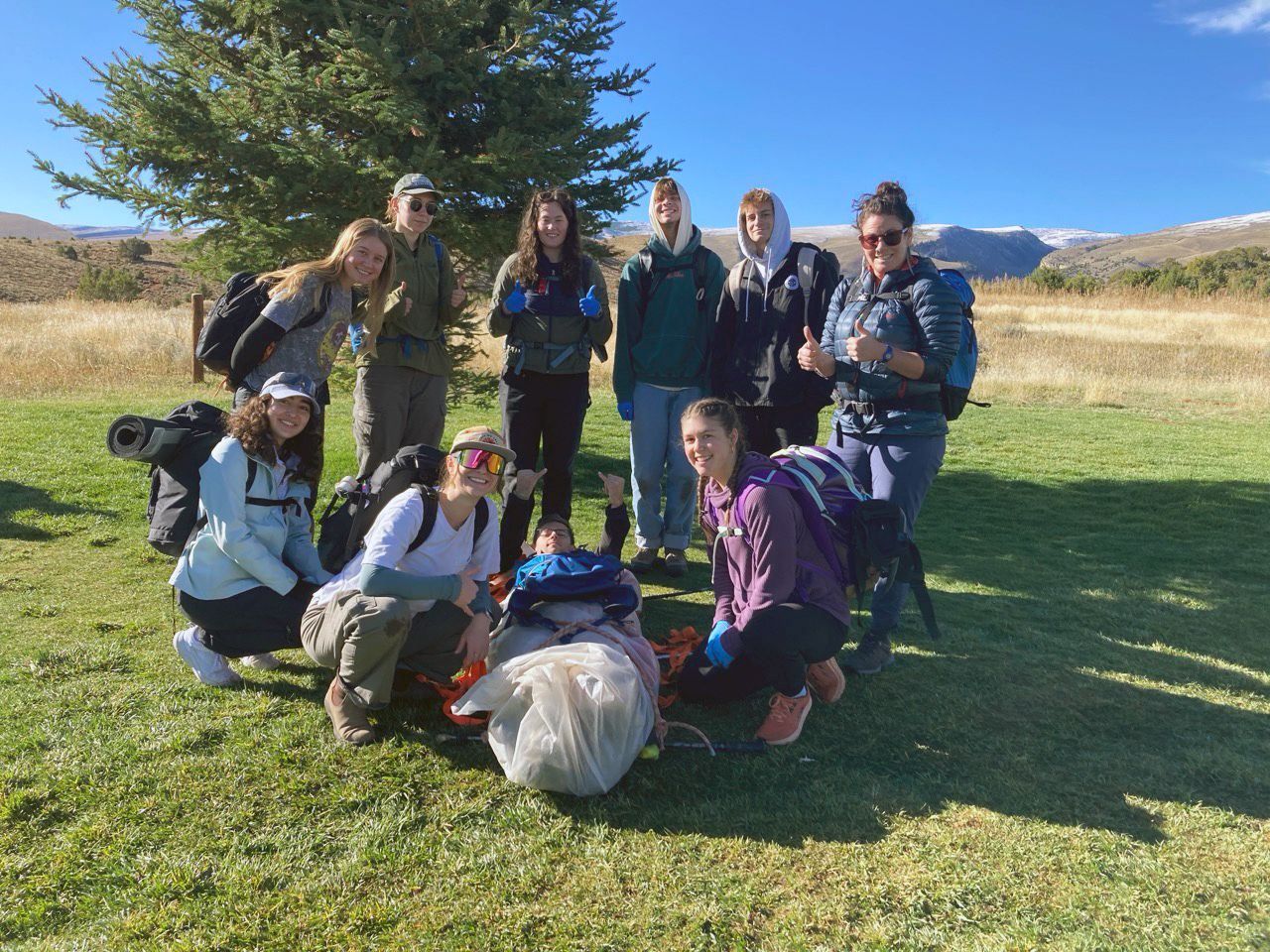 Group standing outside with hiking equipment 