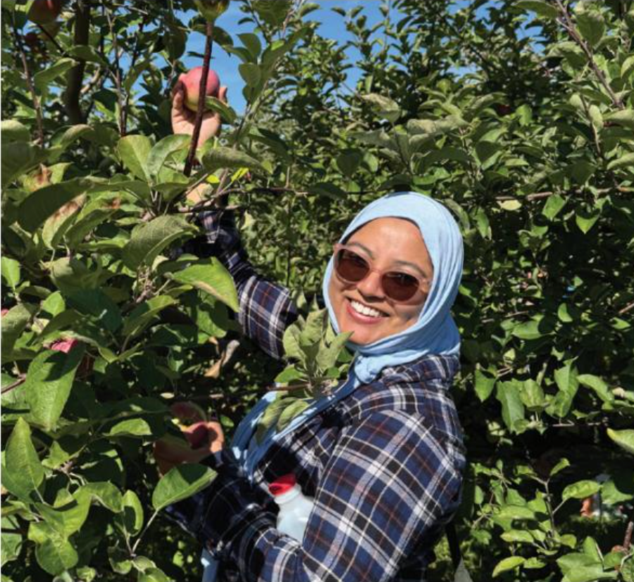 Woman in sunglasses in front of trees