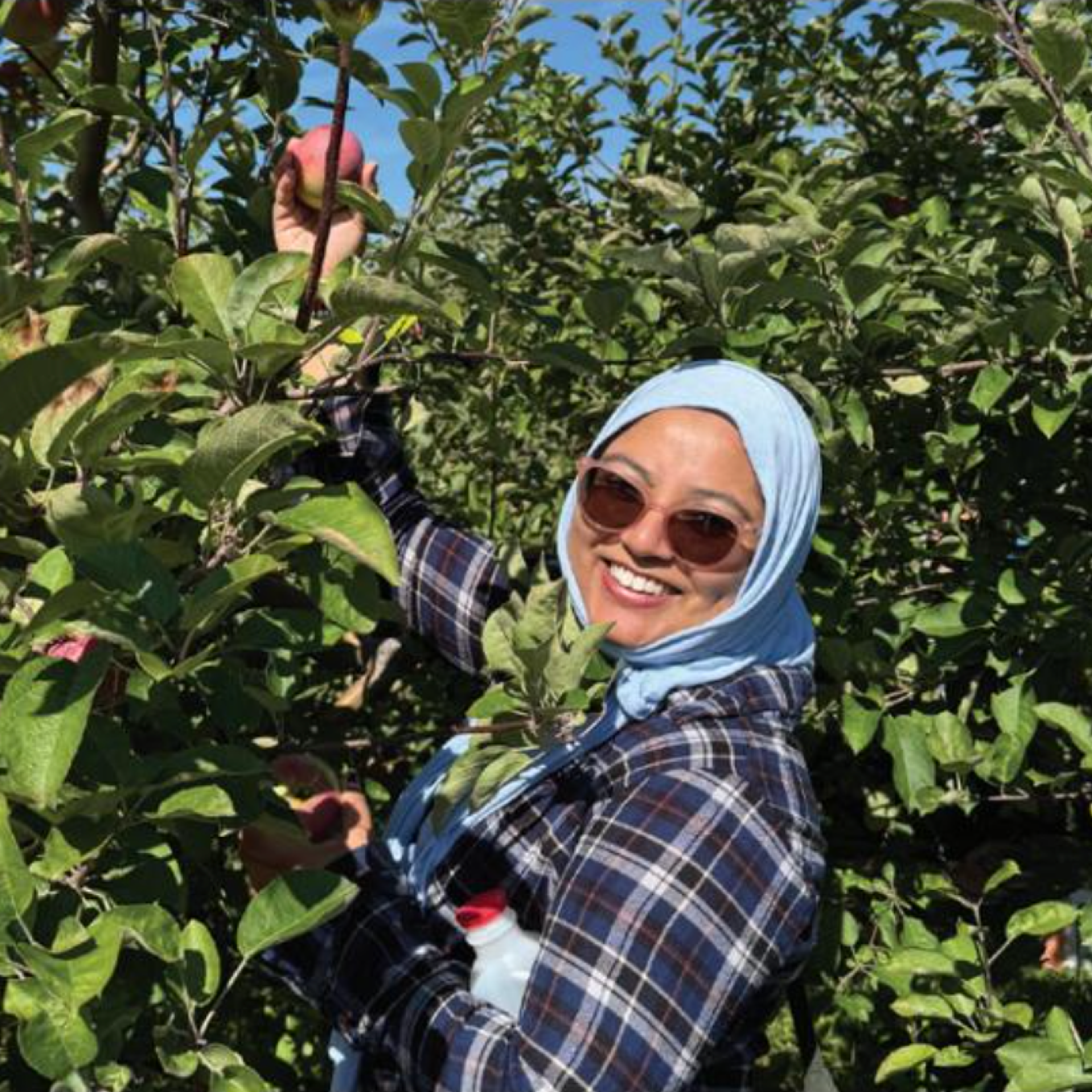 Woman in sunglasses in front of trees