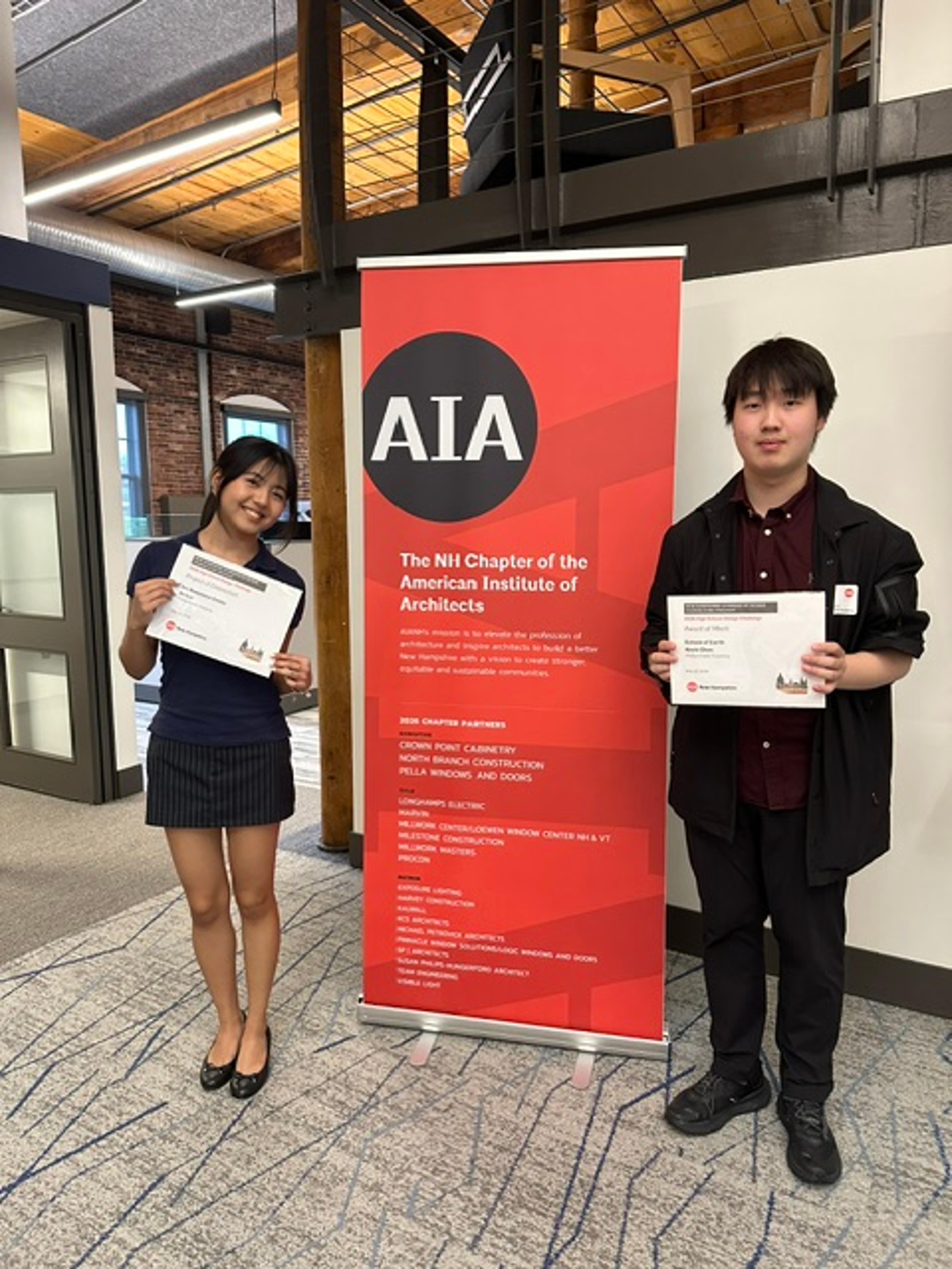students stand in front of sign with awards