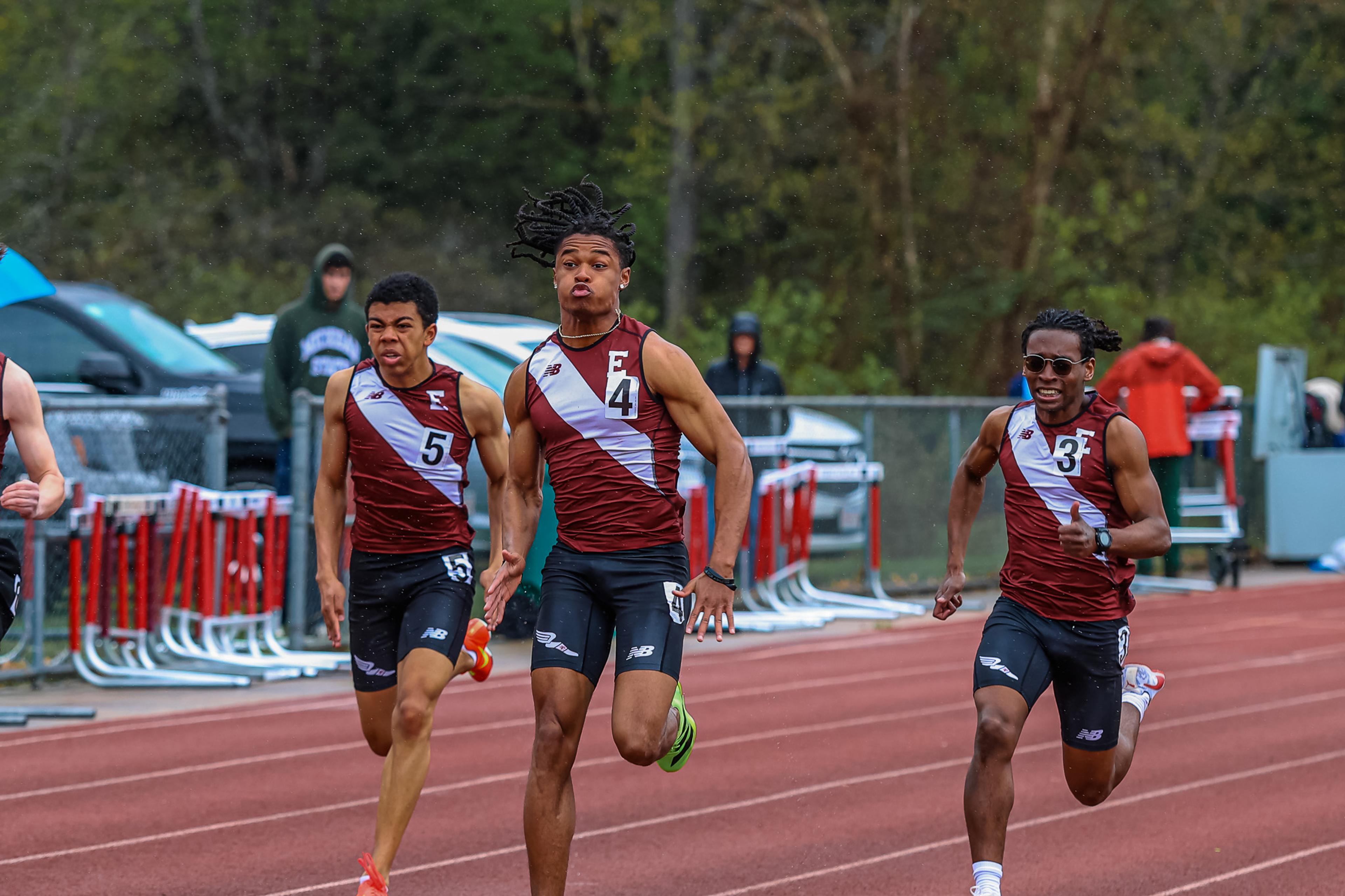 three boys running on outdoor track