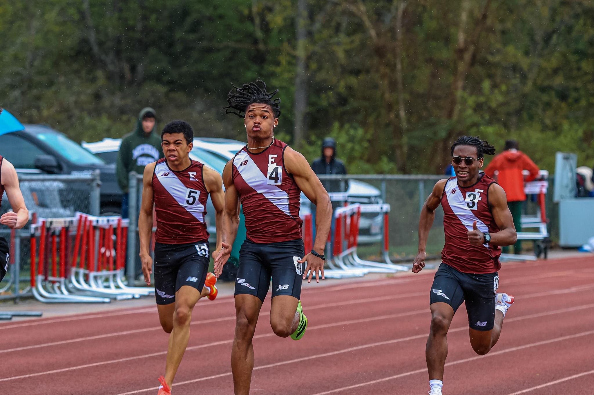 three boys running on outdoor track