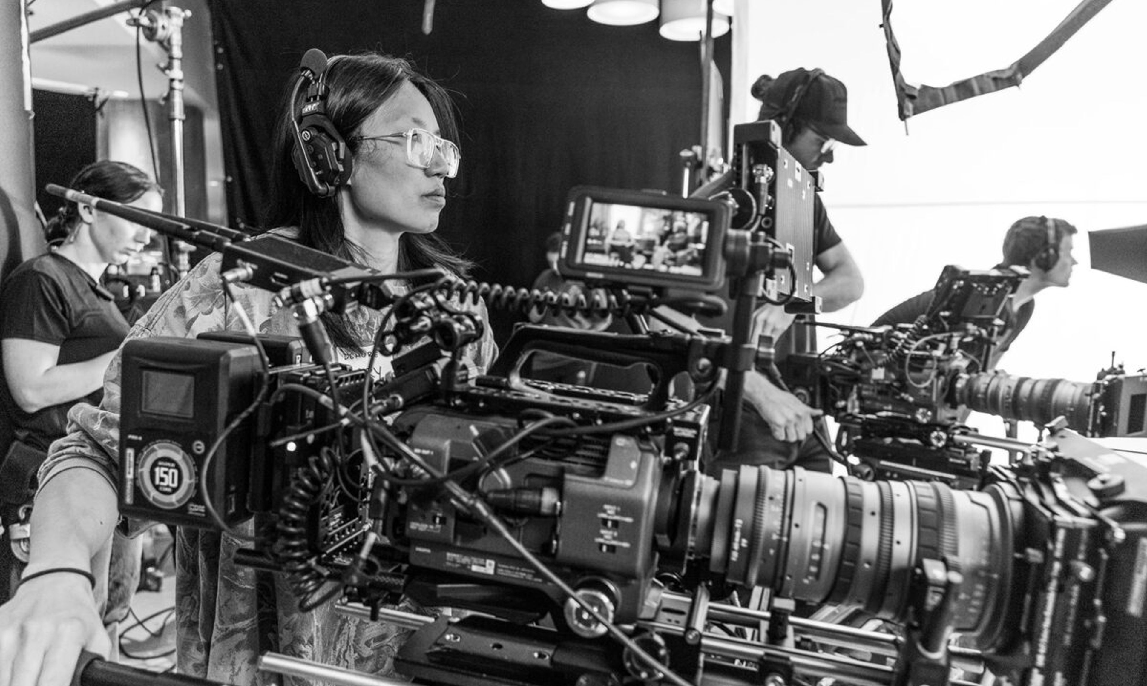 Woman stands with movie camera directing a shot