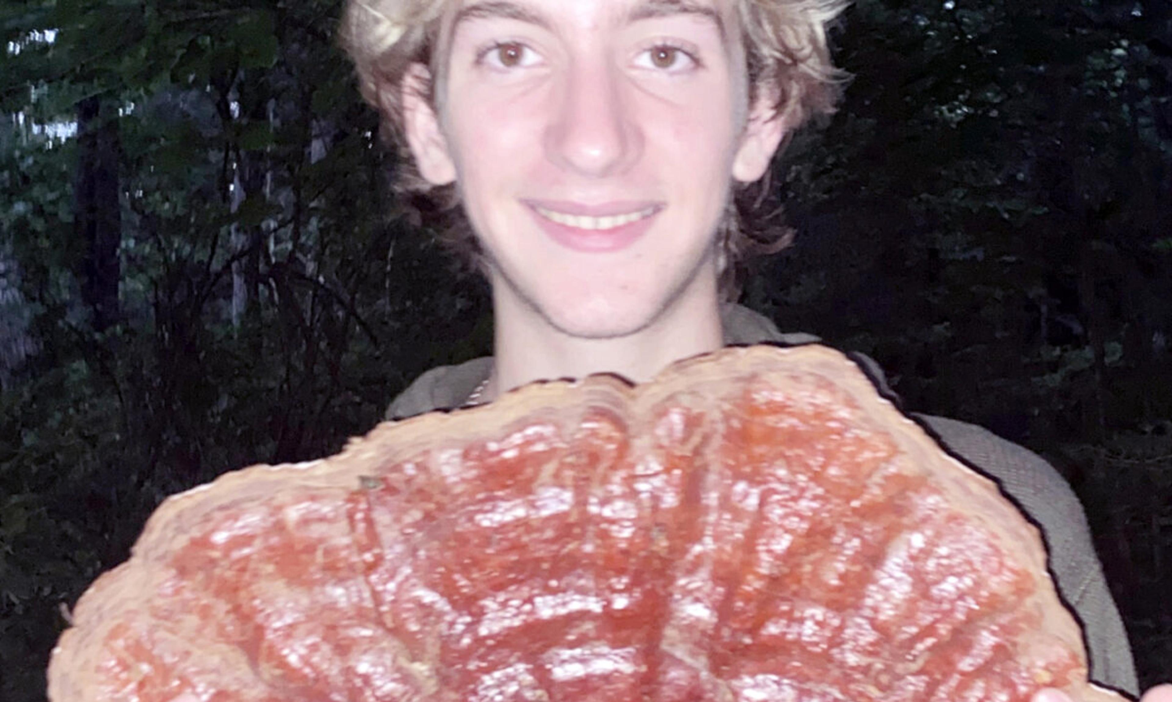 Exeter student stands holding giant shell