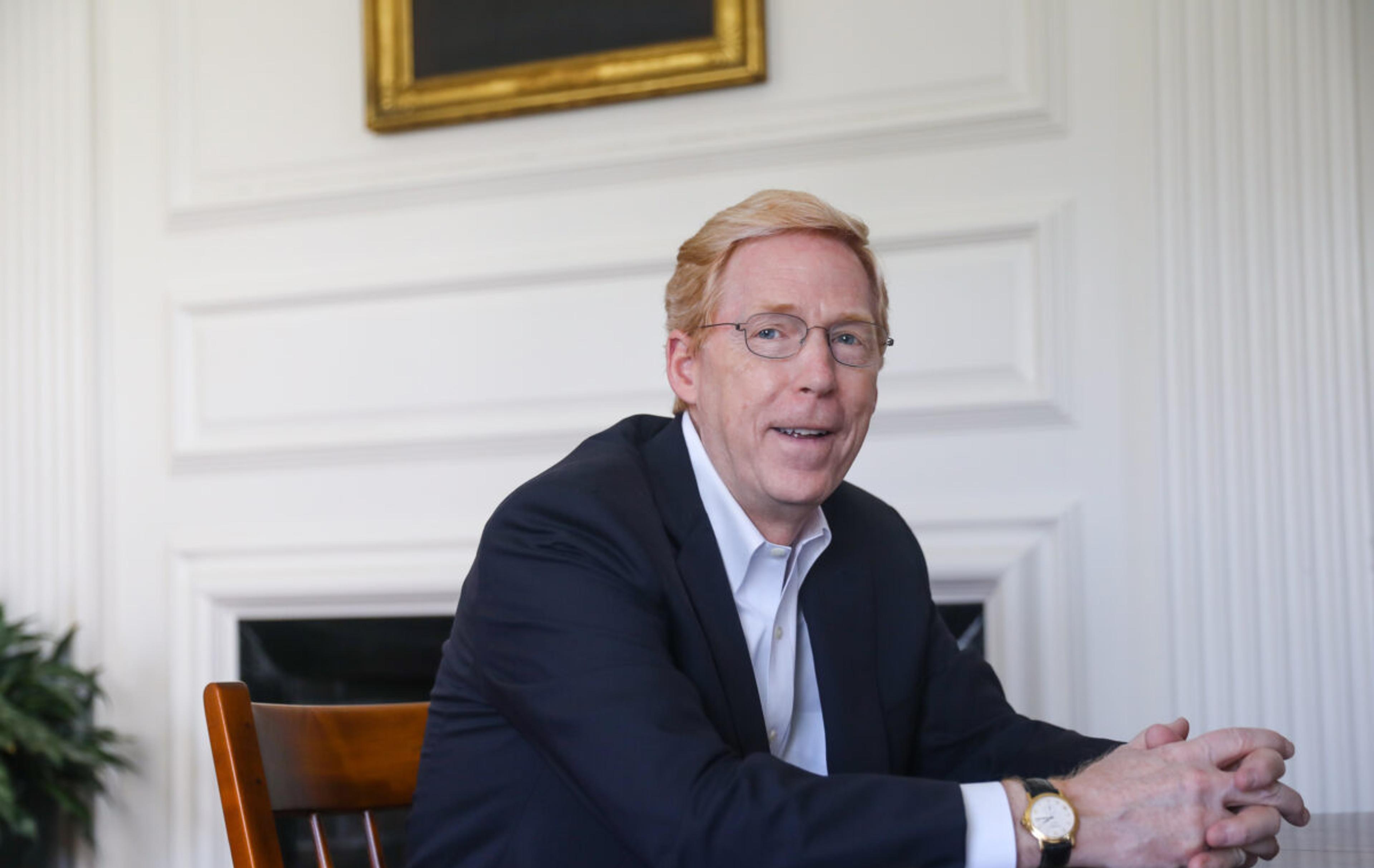 Principal Rawson sits at a wooden table