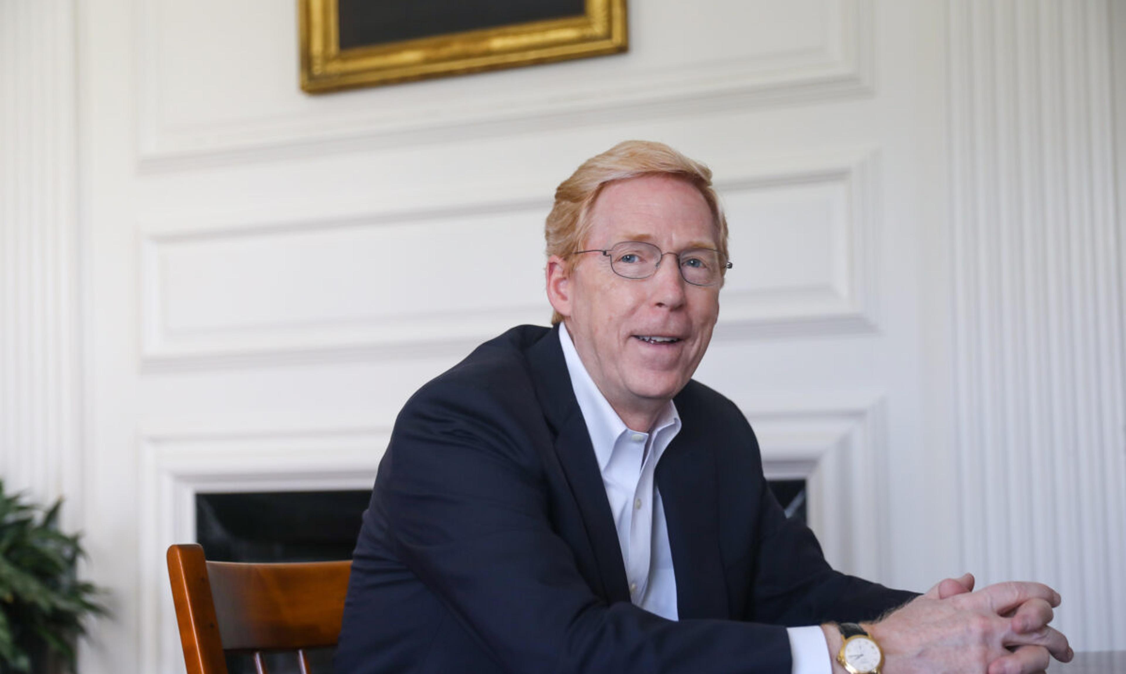 Principal Rawson sits at a wooden table