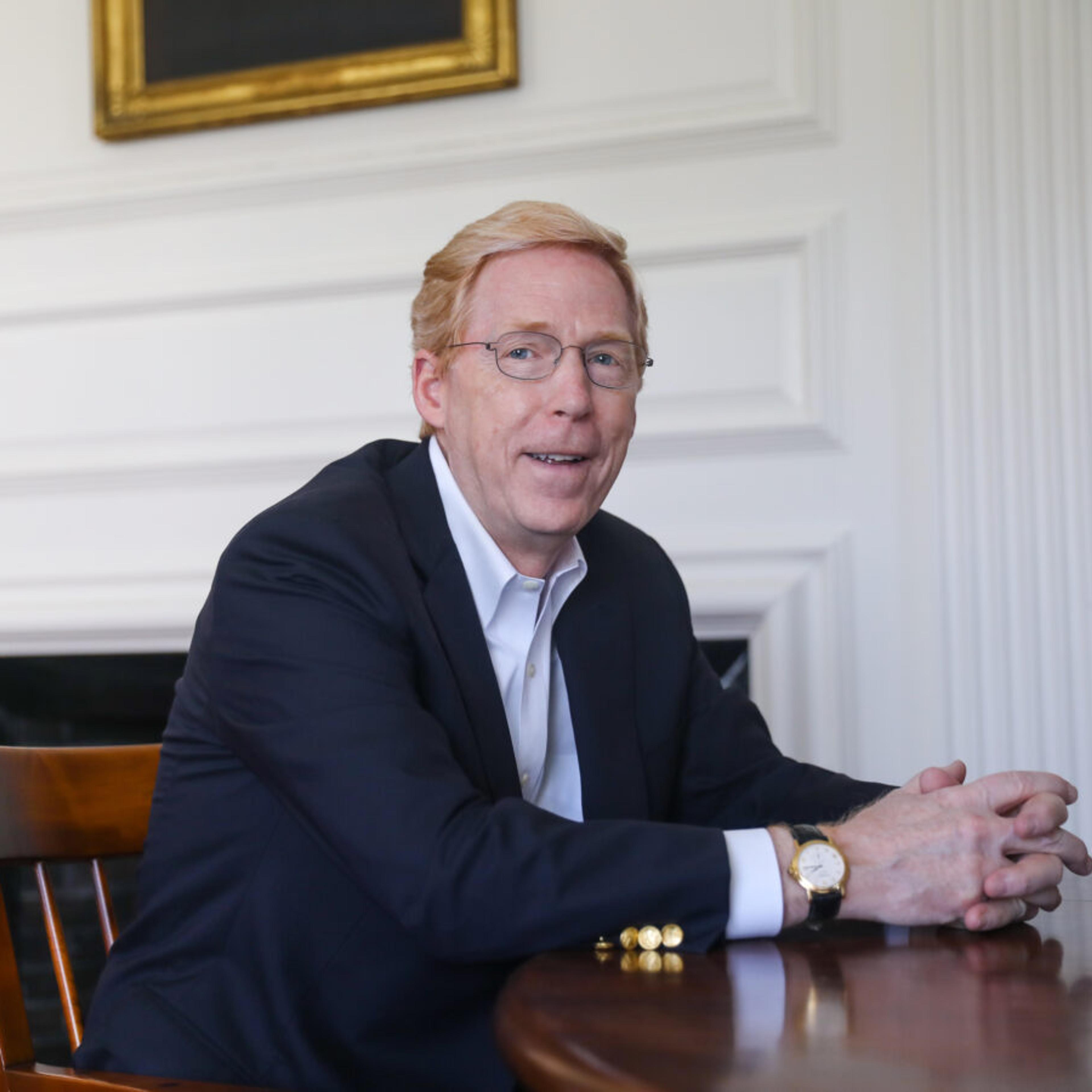 Principal Rawson sits at a wooden table