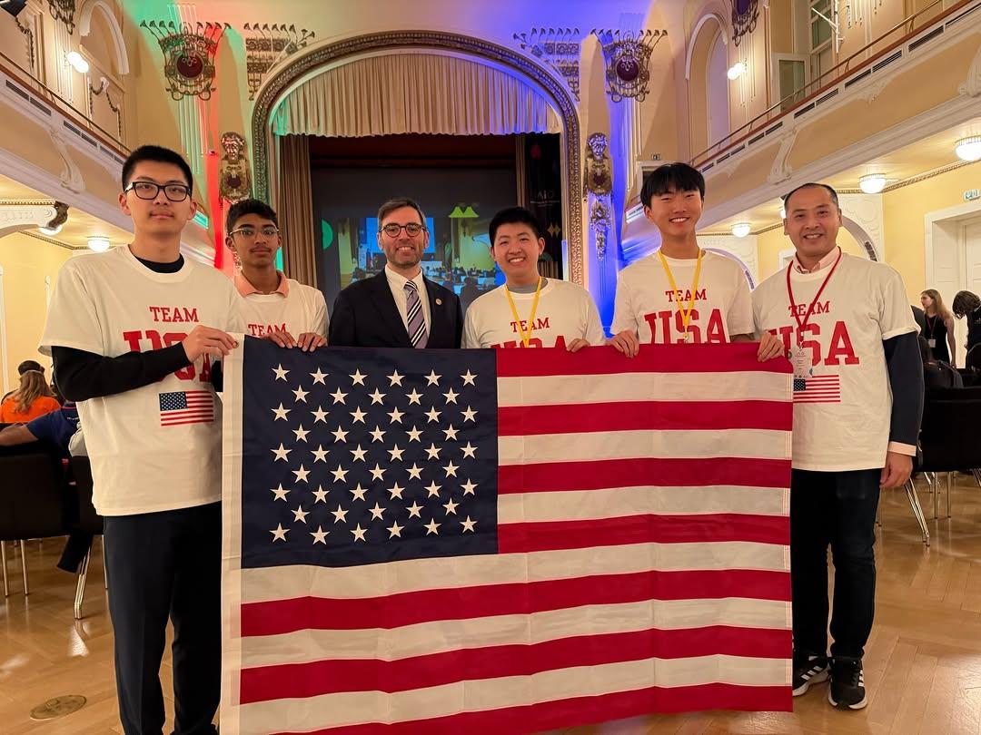 team members stand with american flag.