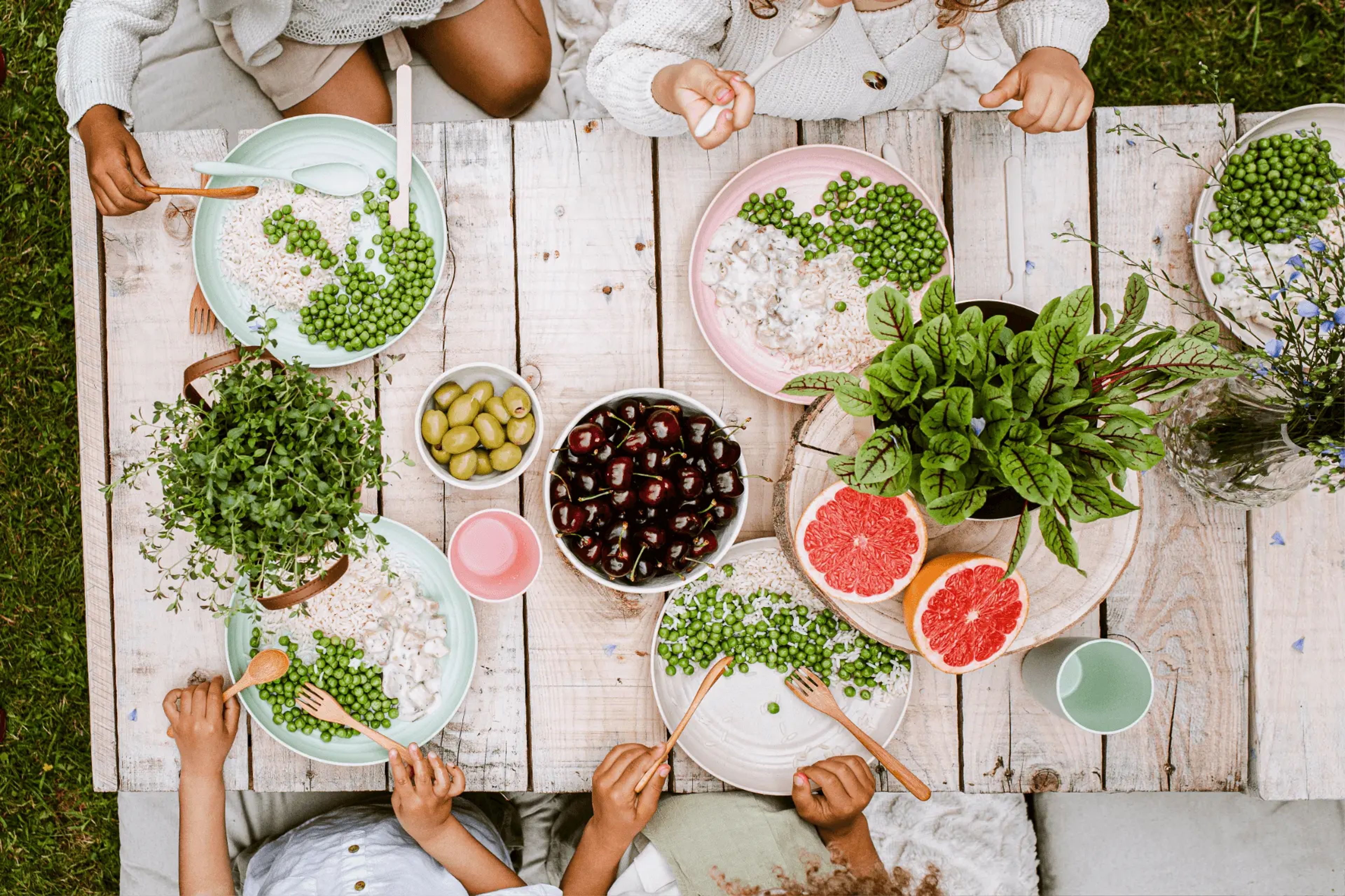 Eine Gruppe von Kindern genießt gesunde Nahrung an einem Picknicktisch.