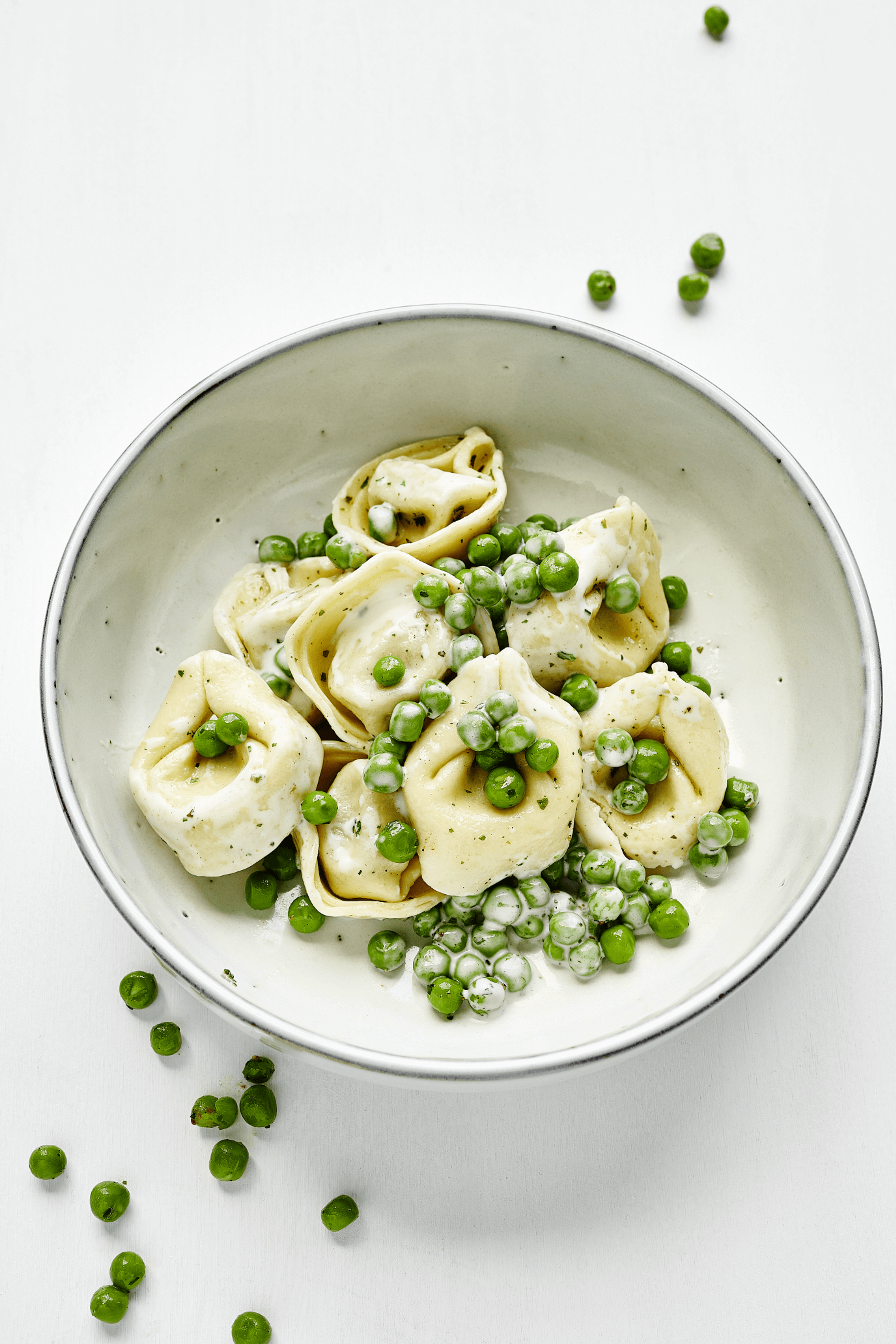 Verlockende Käsetortellini in cremiger Sahnesauce mit Erbsen, eine delikate Mahlzeit aus dem 10-wöchigen Menüplan von min food.