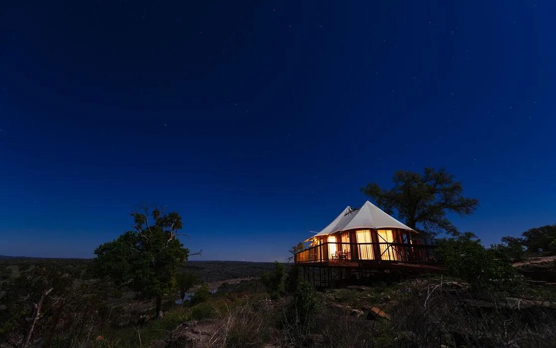 Lit canvas tent suite on a bluff under a starry sky at Walden Retreats, a Johnson City Hill Country wedding venue