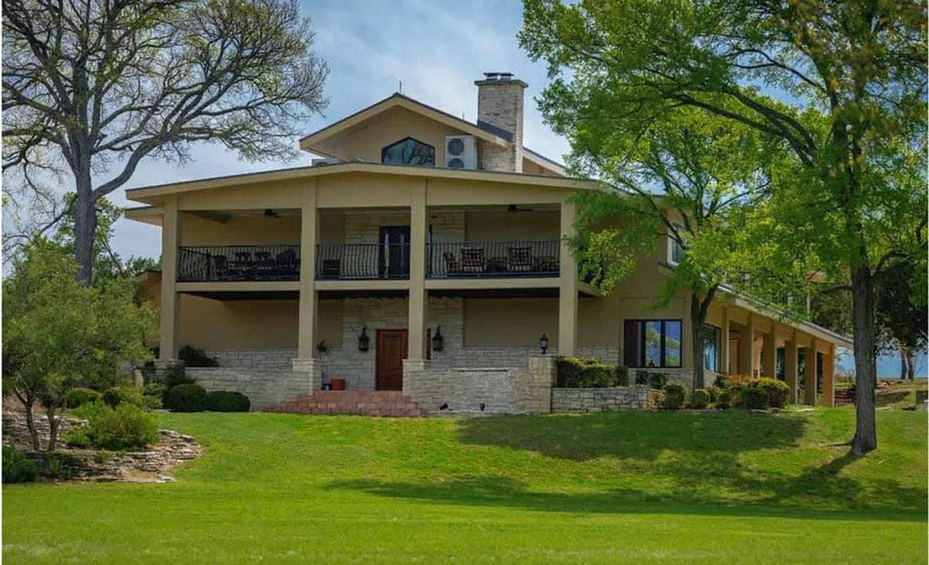 The lodge and its covered porches above the lawn at La Bonne Vie Ranch, a Fredericksburg, Texas wedding venue