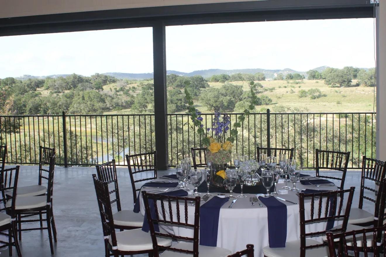 Reception table on the covered deck overlooking the hills at Paniolo Ranch, a Boerne wedding venue with a bed-and-breakfast and spa