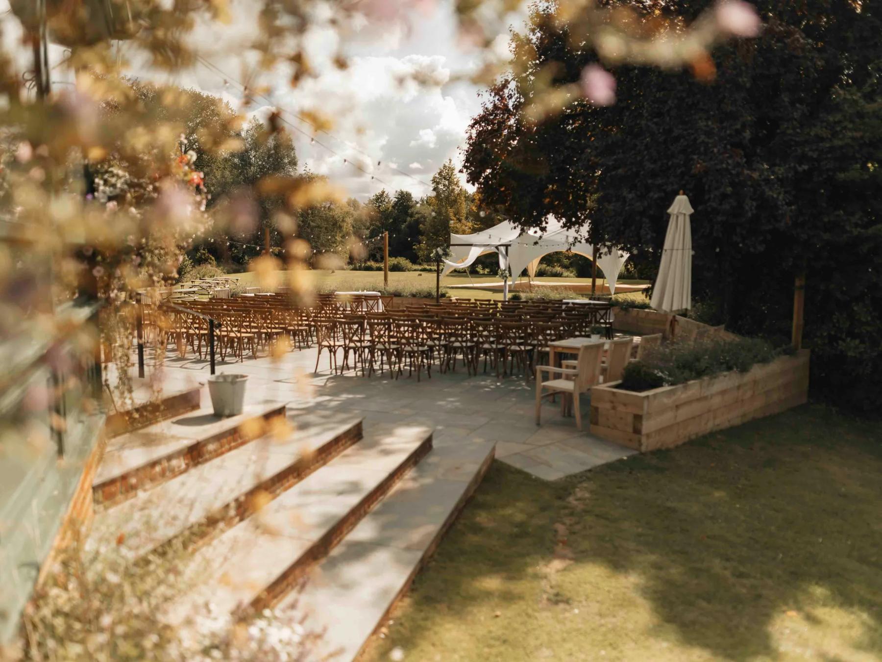 Rows of wooden chairs and a white canopy at an outdoor Texas Hill Country wedding venue at golden hour.