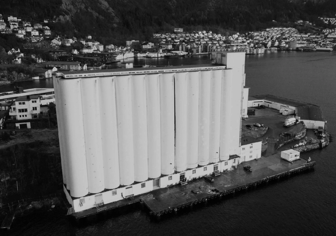 The Nonspace office in Bergen, located inside an old waterfront grain silo at the harbor, shown in a black-and-white aerial photo.