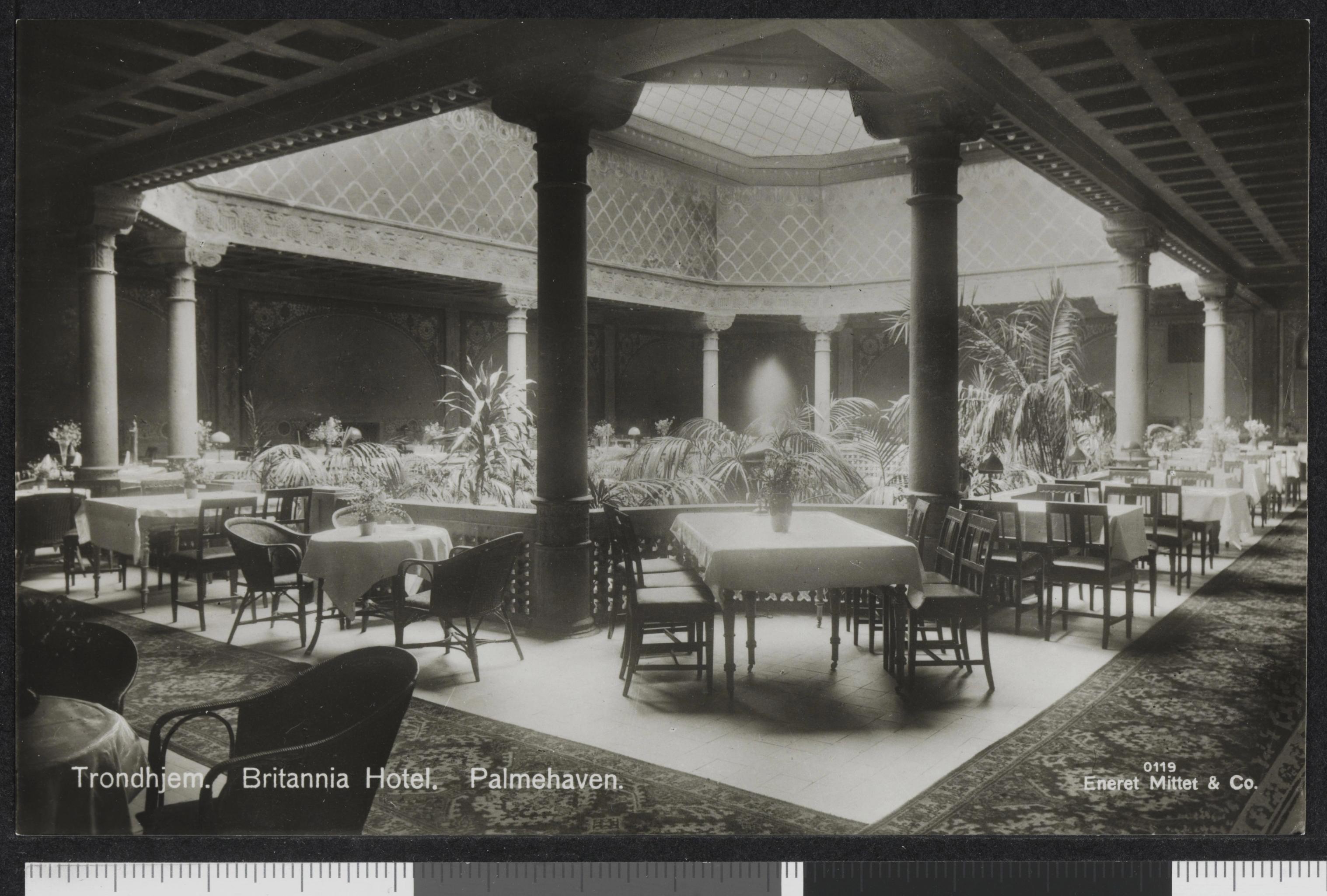 Historic palm court dining room with columns, white tablecloths, and tropical plants at Britannia Hotel — by Nonspace