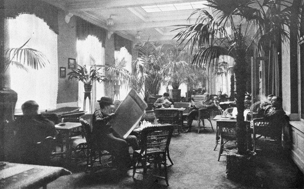 Historic black and white photograph of guests reading newspapers in the lobby at Britannia Hotel