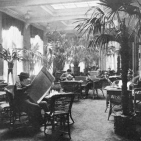 Historic black and white photograph of guests reading newspapers in the lobby at Britannia Hotel