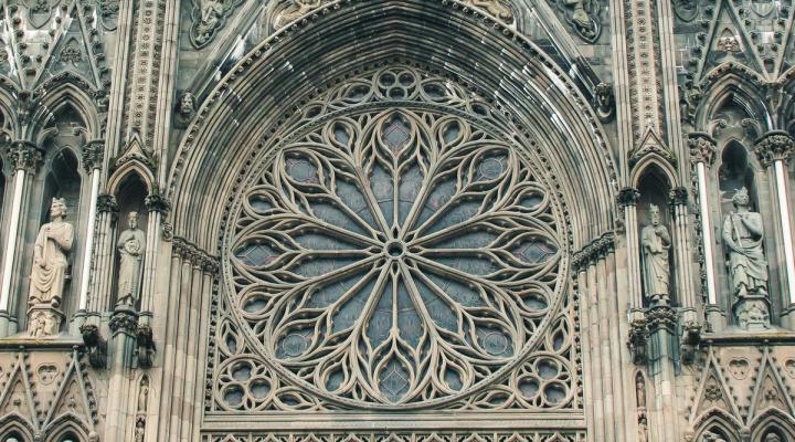 Close-up of the ornate rose window and Gothic stone carvings on the façade of Nidaros Cathedral in Trondheim.