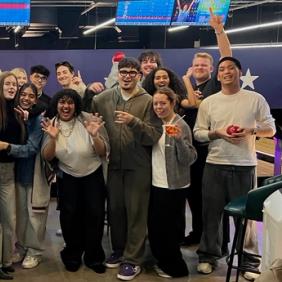 Advertising and Brand Design students celebrating with raised arms after final presentations in the London studio
