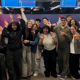 Advertising and Brand Design students celebrating with raised arms after final presentations in the London studio