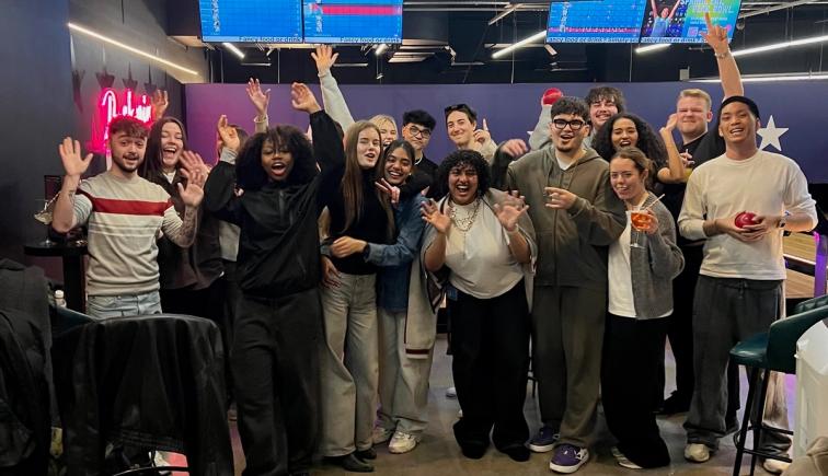 Advertising and Brand Design students celebrating with raised arms after final presentations in the London studio