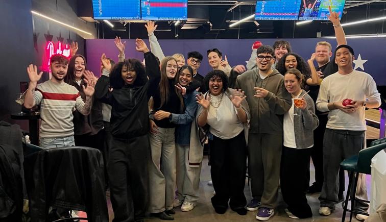 Advertising and Brand Design students celebrating with raised arms after final presentations in the London studio