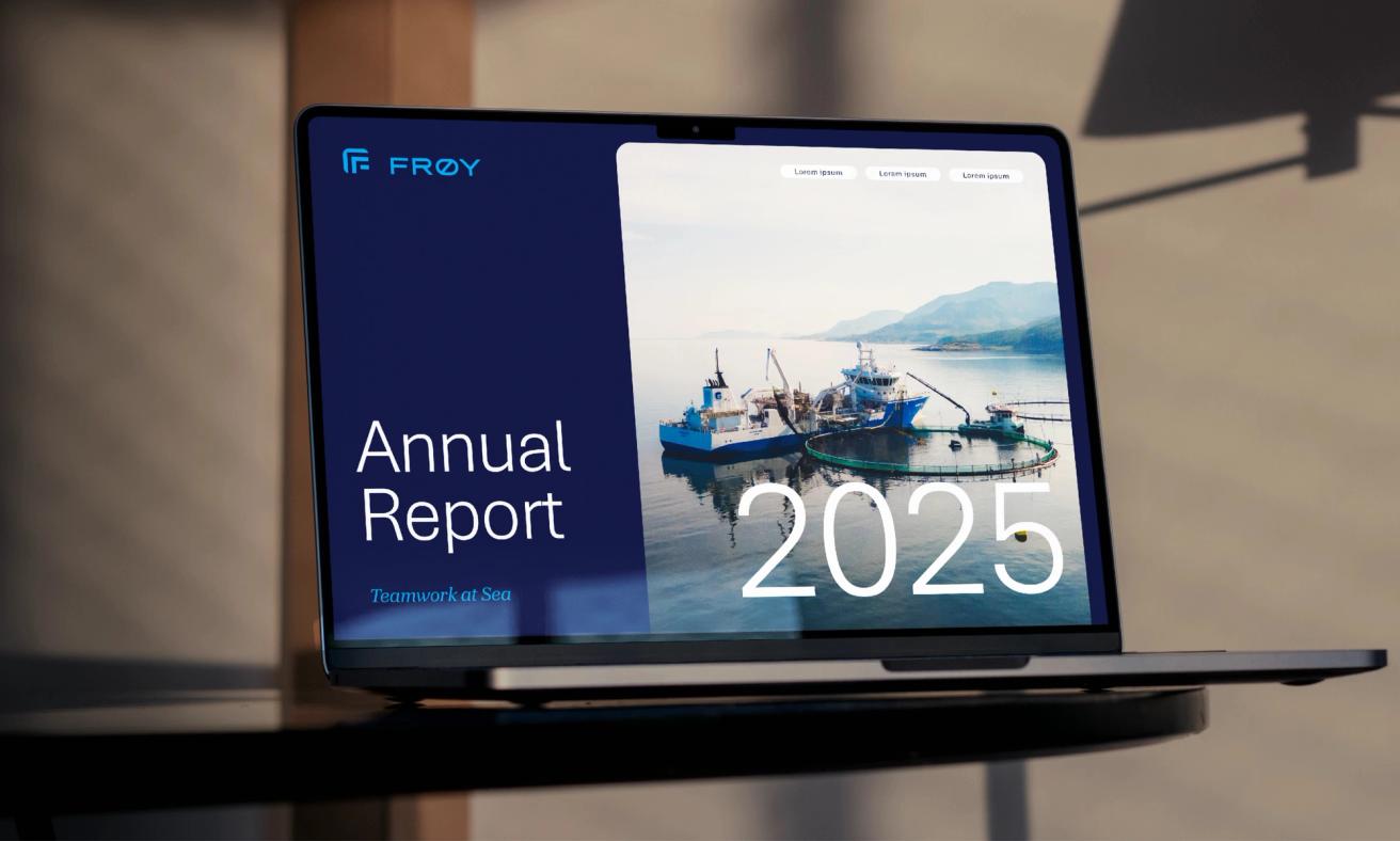 A laptop displaying Frøy's 2025 Annual Report featuring a fishing vessel and aquaculture pen at sea — by Nonspace