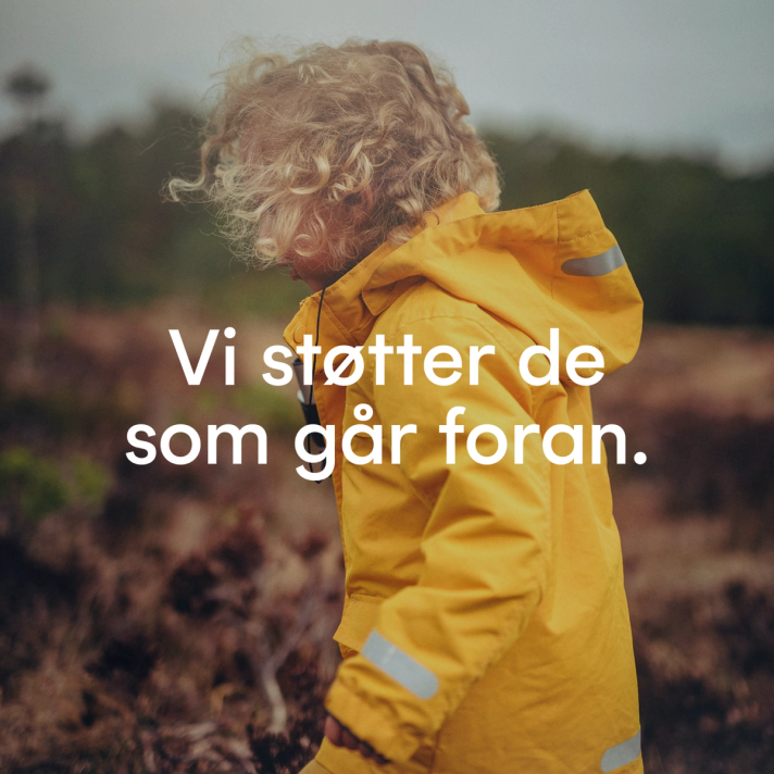 Et barn med krøllete hår i gul regnjakke står i naturen med teksten "Vi støtter de som går foran" — av Nonspace