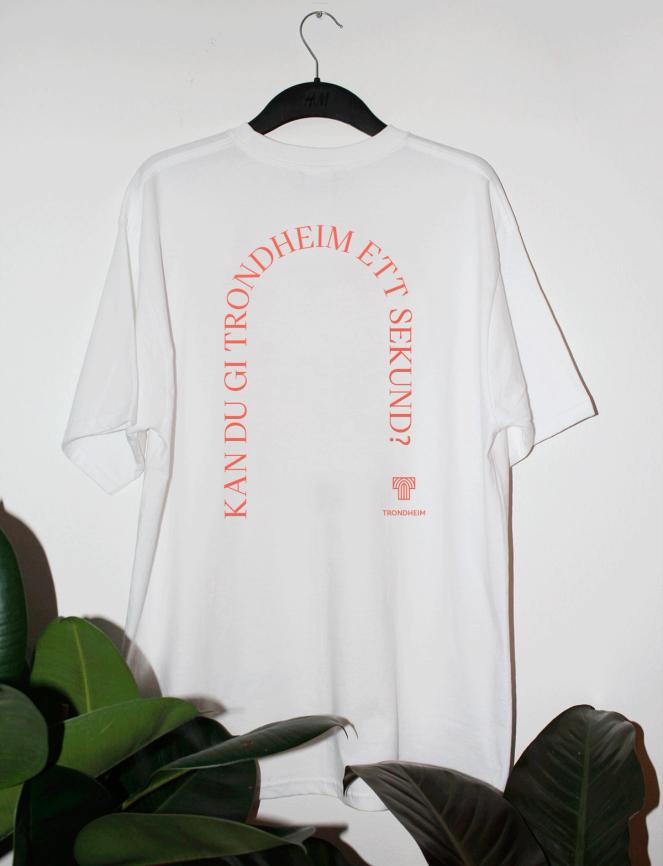 White t-shirt with coral text reading "Kan du gi Trondheim ett sekund?" arranged in an arch shape — by Nonspace