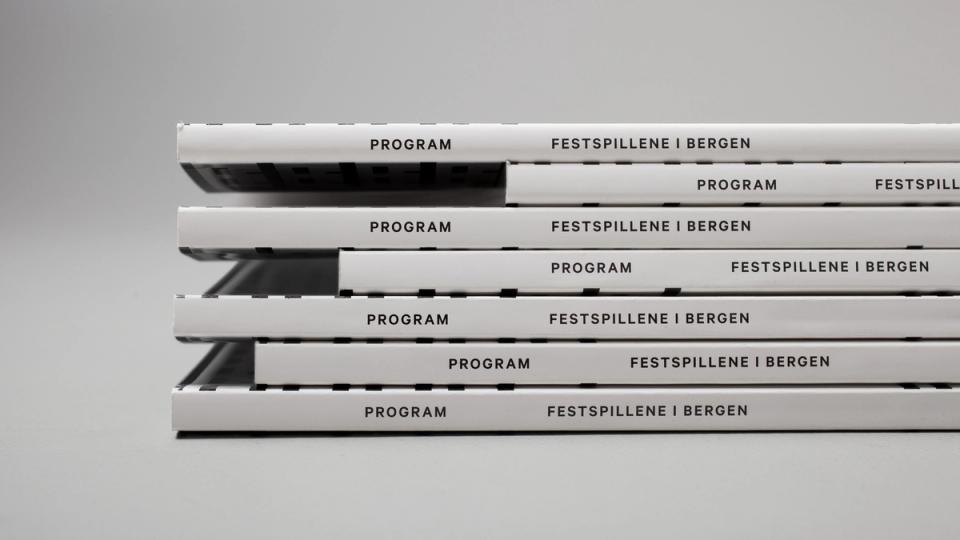 A stack of white program booklets for Festspillene i Bergen arts festival with minimalist black typography — by Nonspace