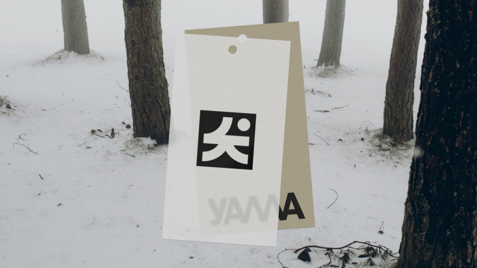 Two overlapping clothing tags featuring the YAMA logo displayed against a snowy forest backdrop — by Nonspace