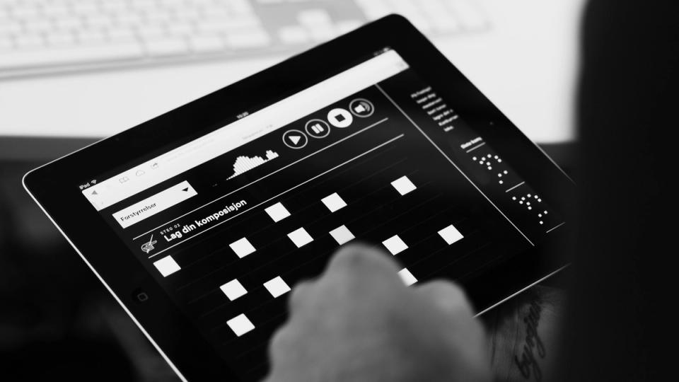 A hand interacting with an iPad music composition app showing a grid-based sequencer interface in Norwegian — by Nonspace