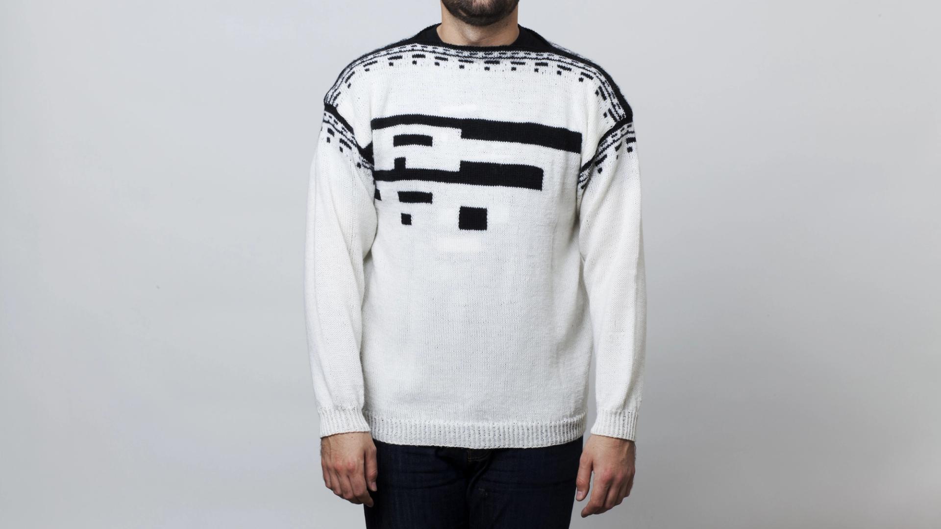 A man wearing a white knitted sweater with abstract black geometric patterns on the chest and shoulders — by Nonspace