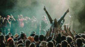 A vibrant concert scene with a crowd surfer and lively audience members enjoying a live performance