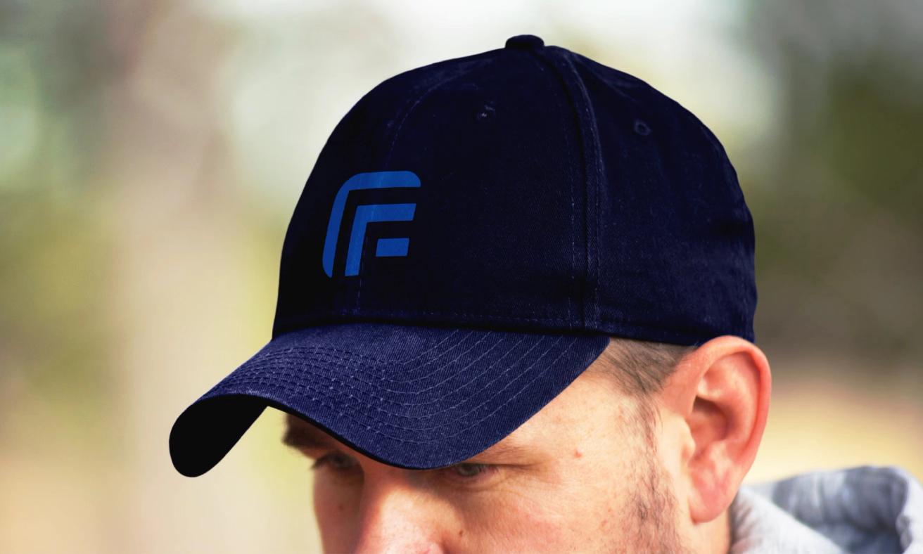 En mann med mørkeblå caps med blå FF-logo sett fra siden i naturlig utendørsbelysning — av Nonspace