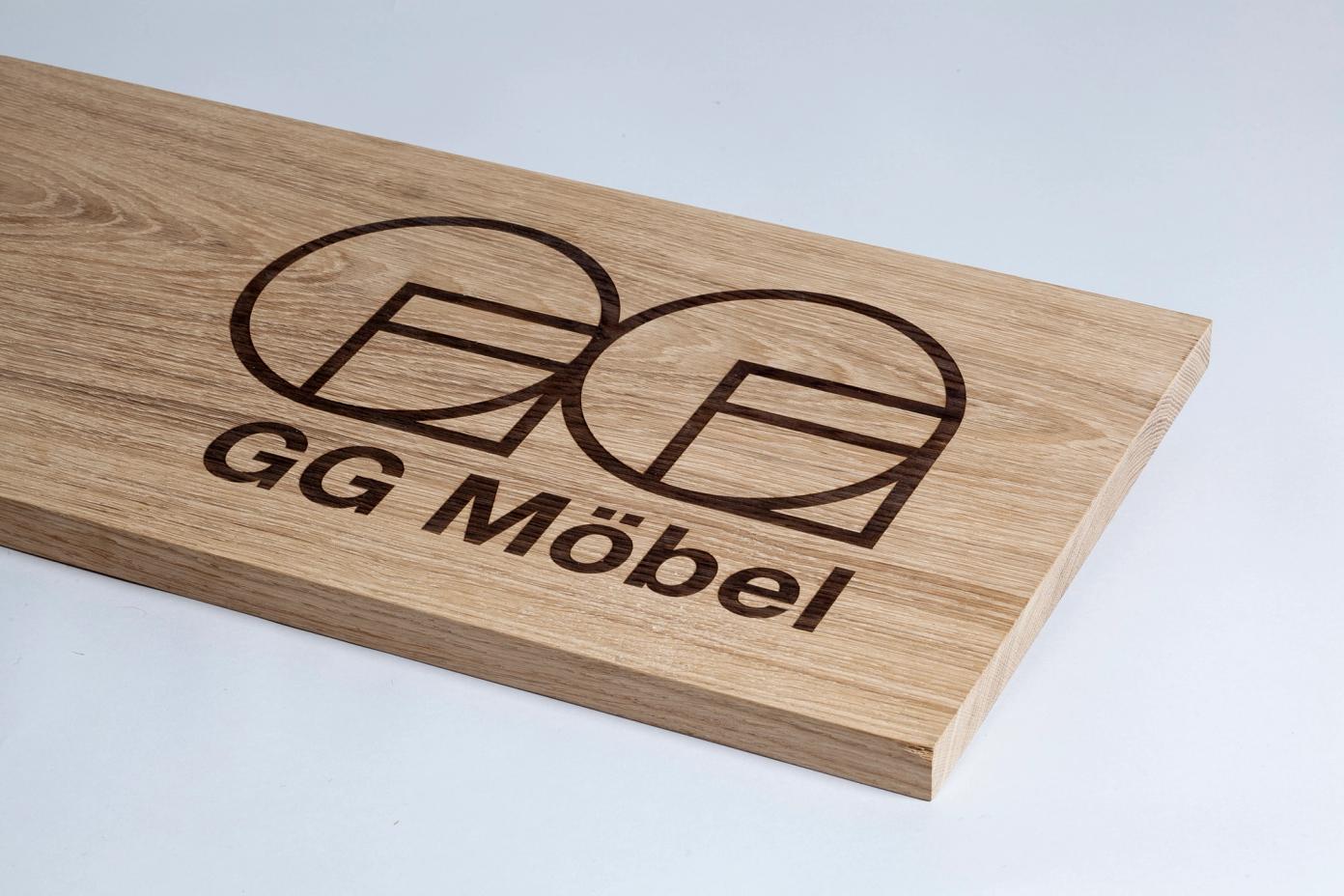 En treplate med inngravert logo og teksten "GG Möbel" for et møbelmerke — av Nonspace