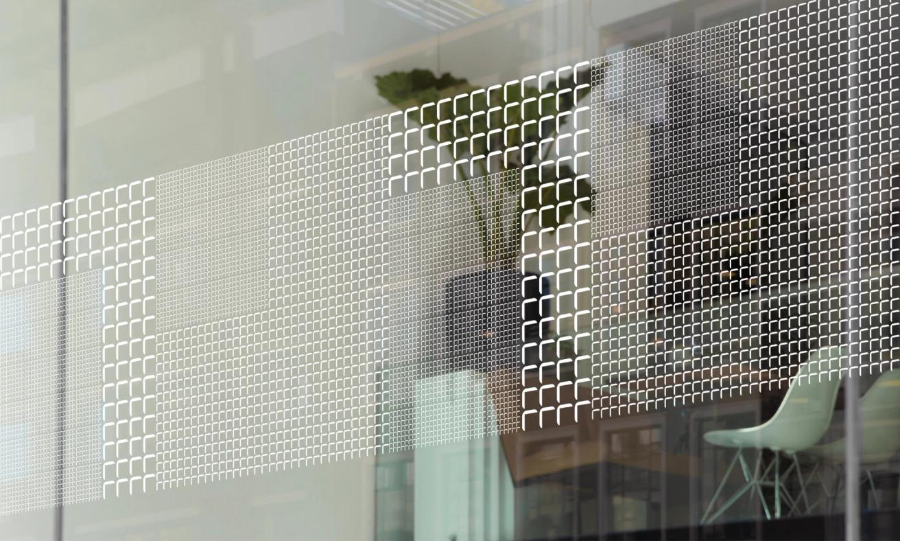 A glass office partition with decorative white geometric grid pattern featuring varying densities of small squares — by Nonspace