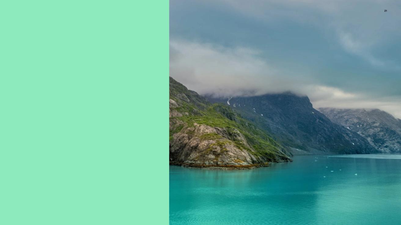 A turquoise fjord with rugged green mountains under cloudy skies alongside a mint green color block — by Nonspace