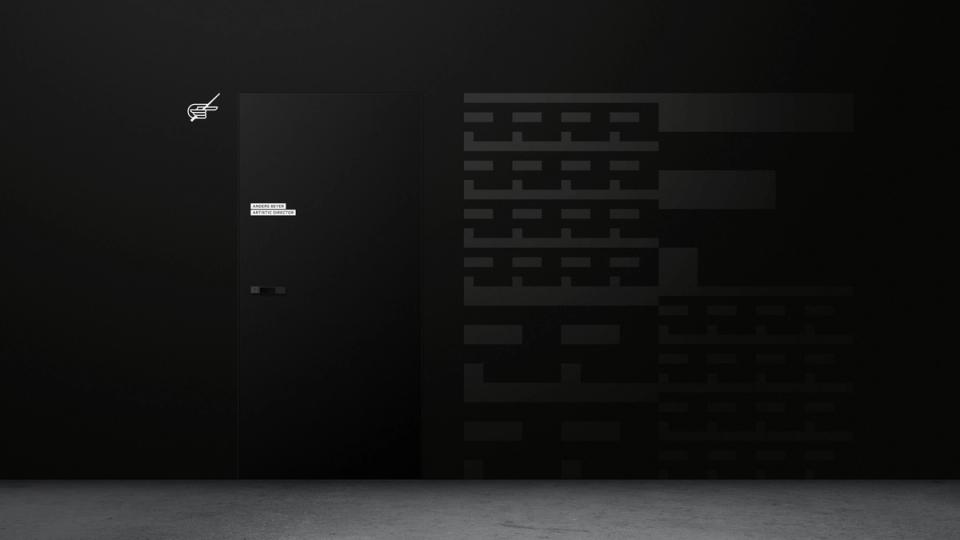 En mørk vegg med en dør merket Anders Beyer Artistic Director og et minimalistisk logo ved siden av en tekstblokk — av Nonspace