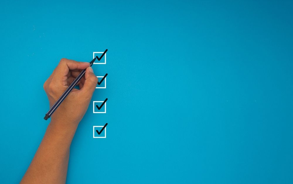 Hand checking boxes on a checklist illustrating steps to prepare for a New Jersey expungement in 2026