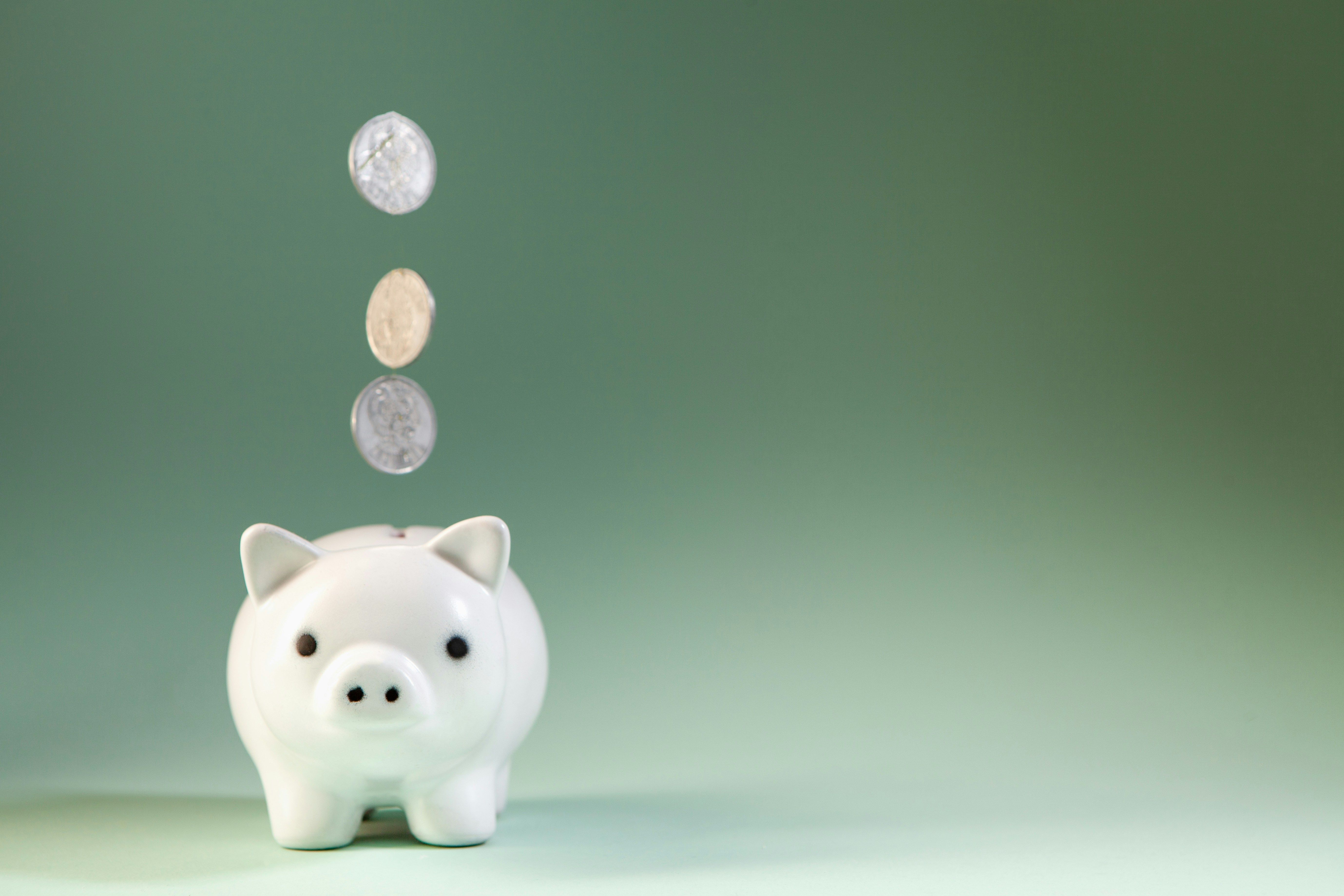 White piggy bank with coins dropping in, showing how a criminal record can affect financial aid for college