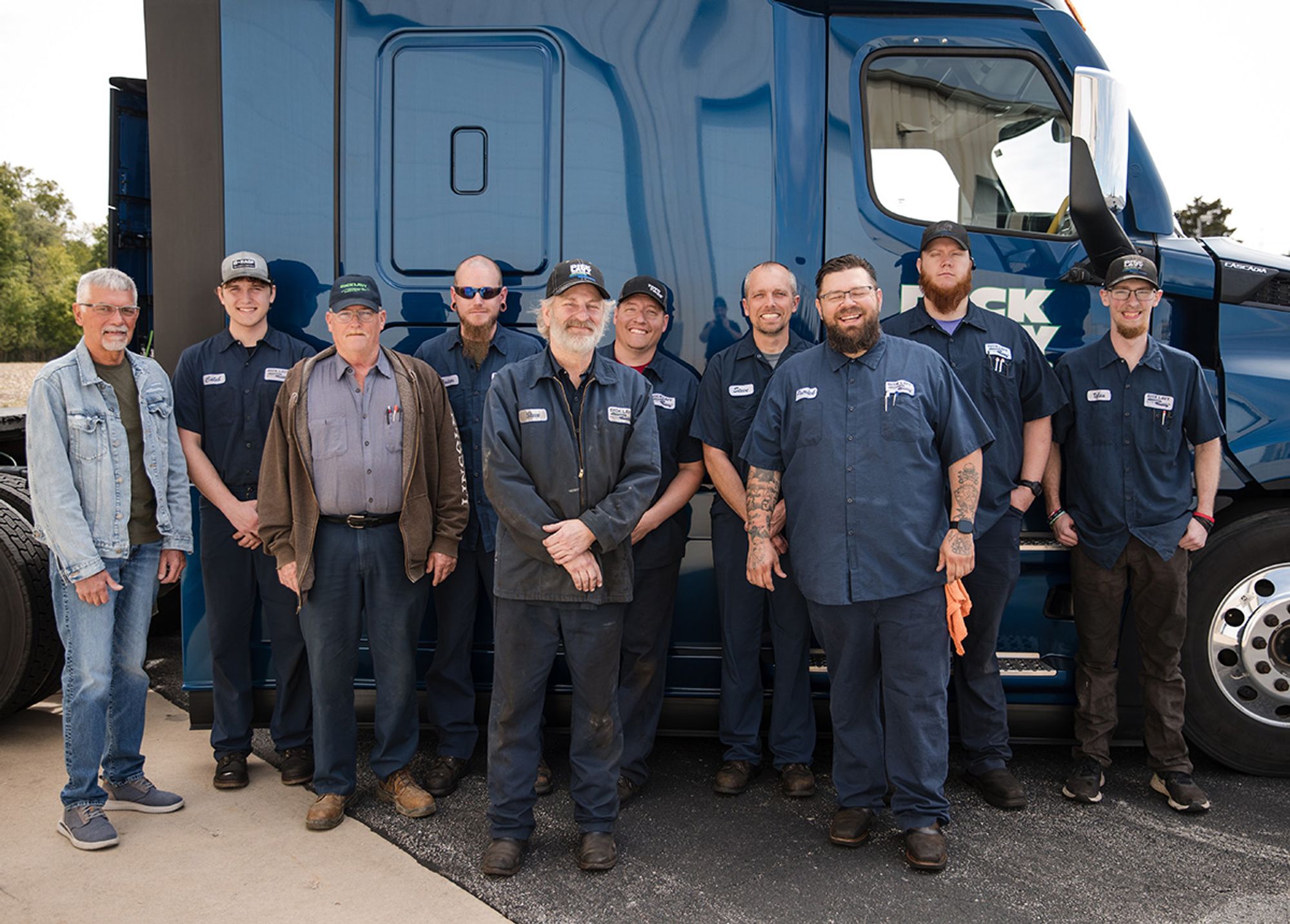 Dick Lavy Trucking shop crew standing in front of a Freightliner Cascadia