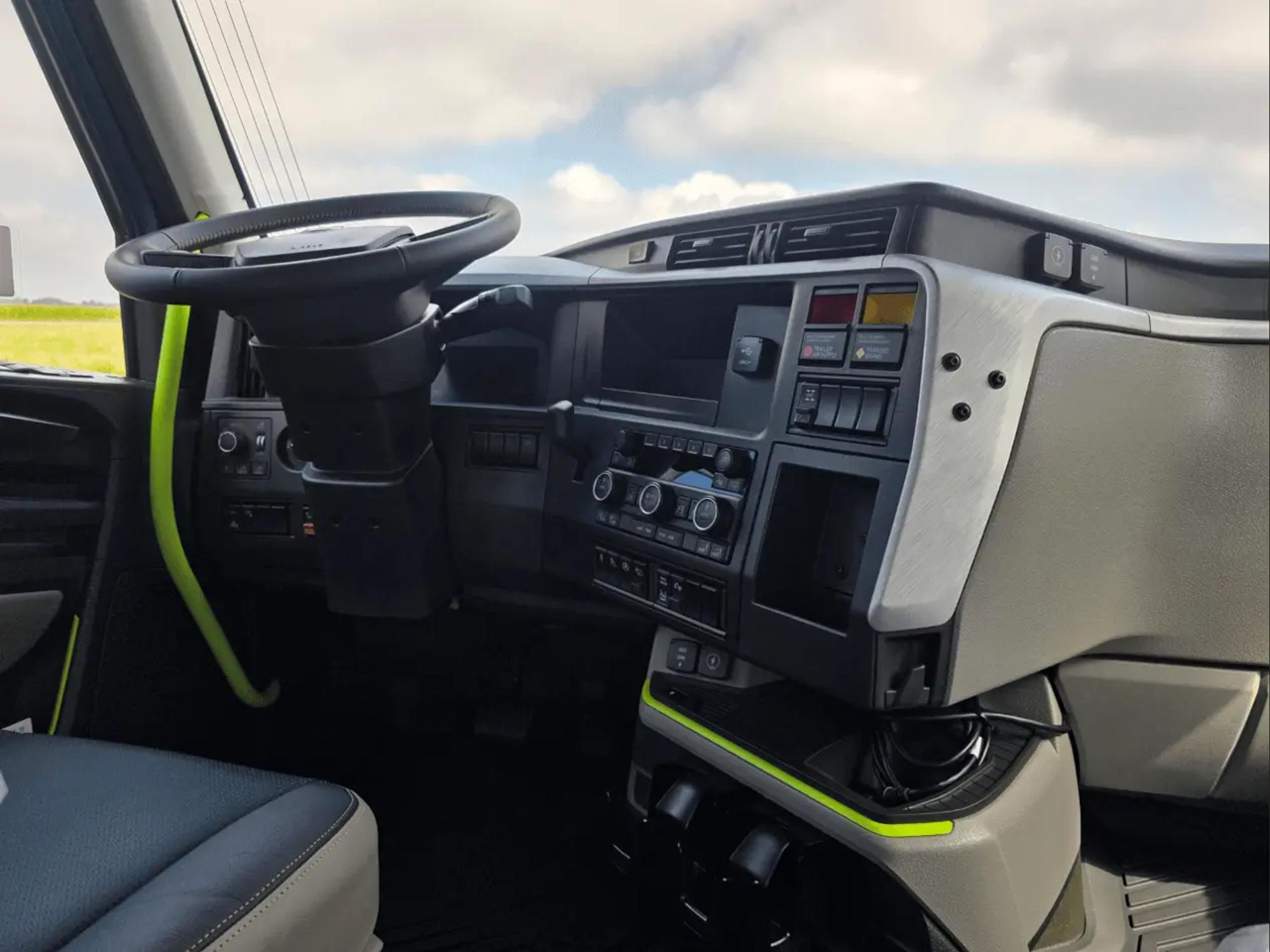 Inside a Dick Lavy late-model tractor cab — open highway ahead through the windshield