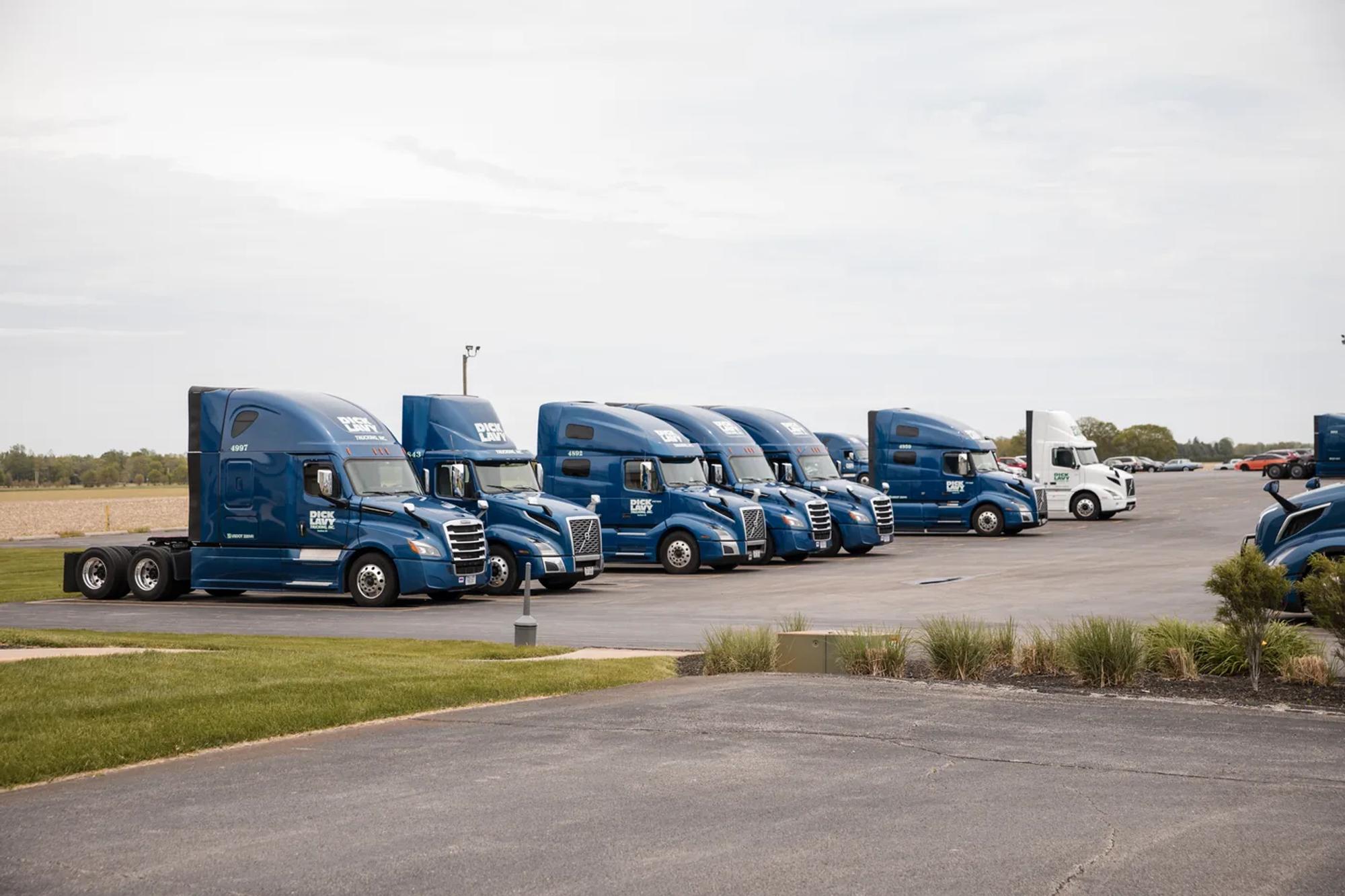 Blue Dick Lavy Trucking tractors lined up at the yard, ready for dedicated lanes