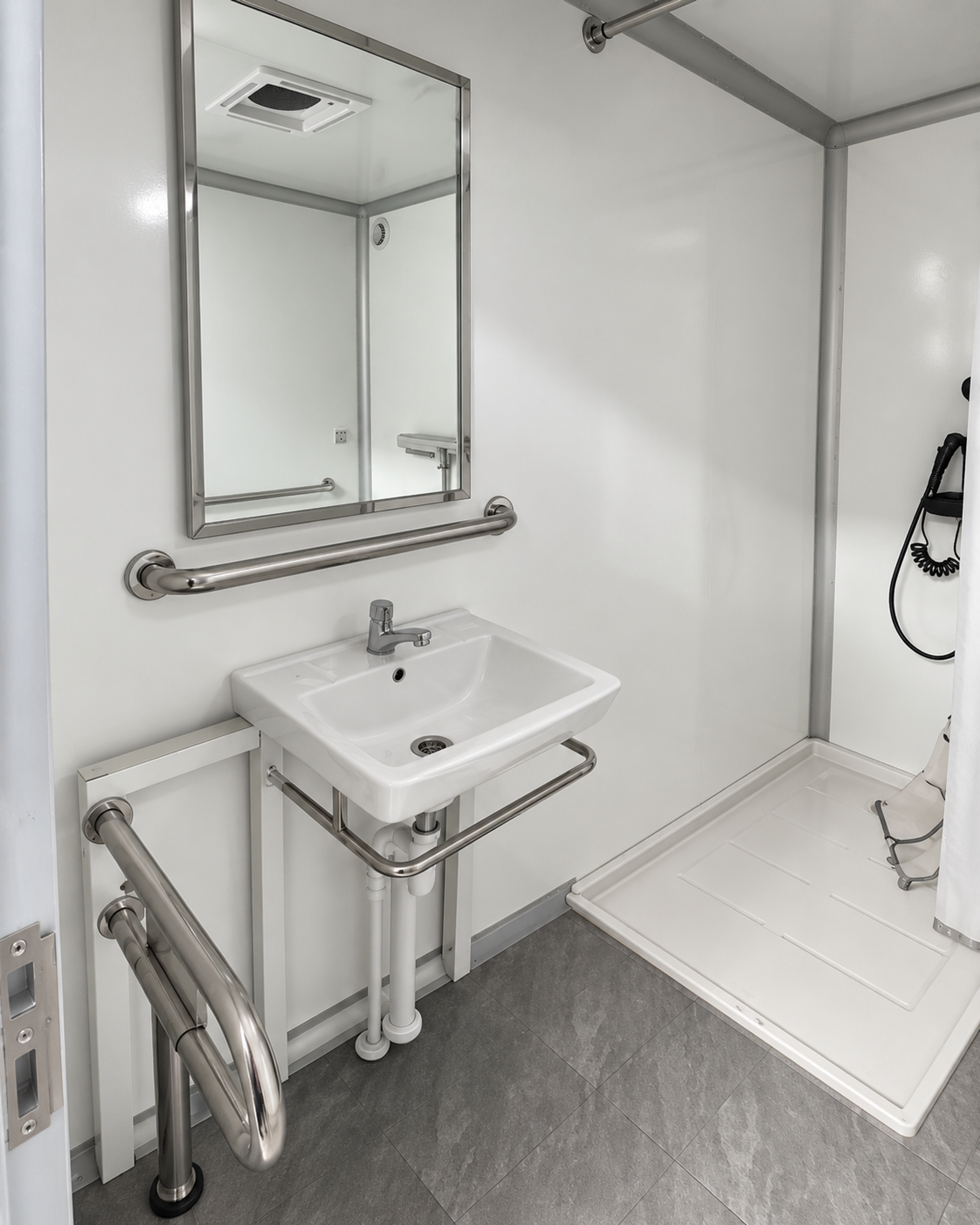 Wall-hung sink with grab bar, mirror and in-stall shower tray